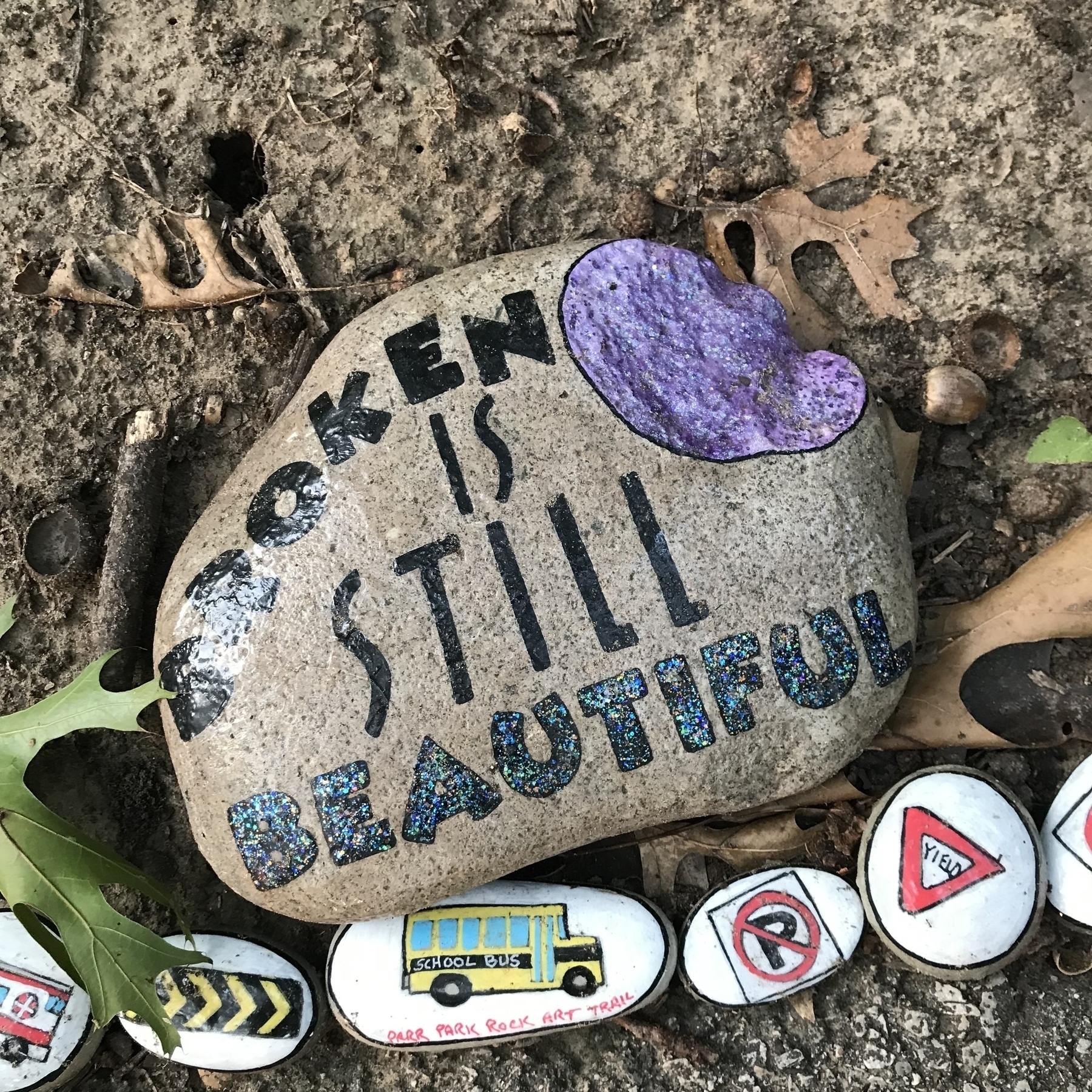 A rock at the Parr Park Rock Art Trail painted with “Broken is still beautiful”